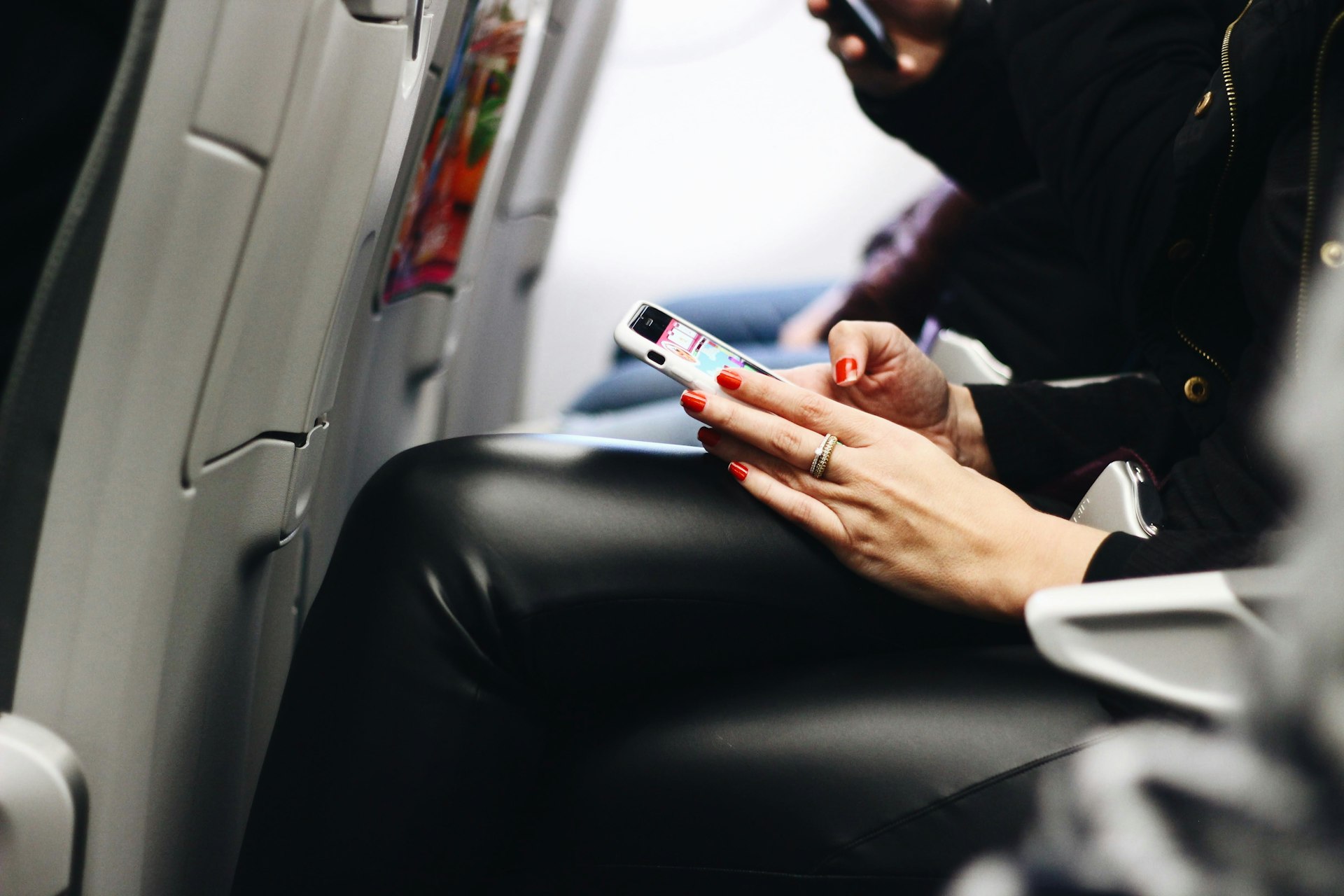 woman using her phone on thei airplane to file expat taxes